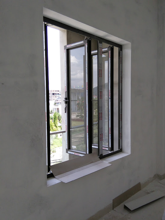 Cửa sổ nhôm kính mở quay nhiều cánh đang lắp đặt trong phòng xây thô